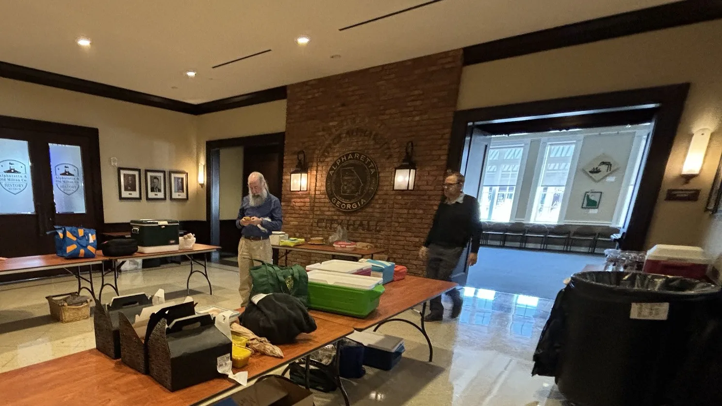 The lobby of Alpharetta City Hall at 2 Park Plaza, with the city seal on the brick wall.