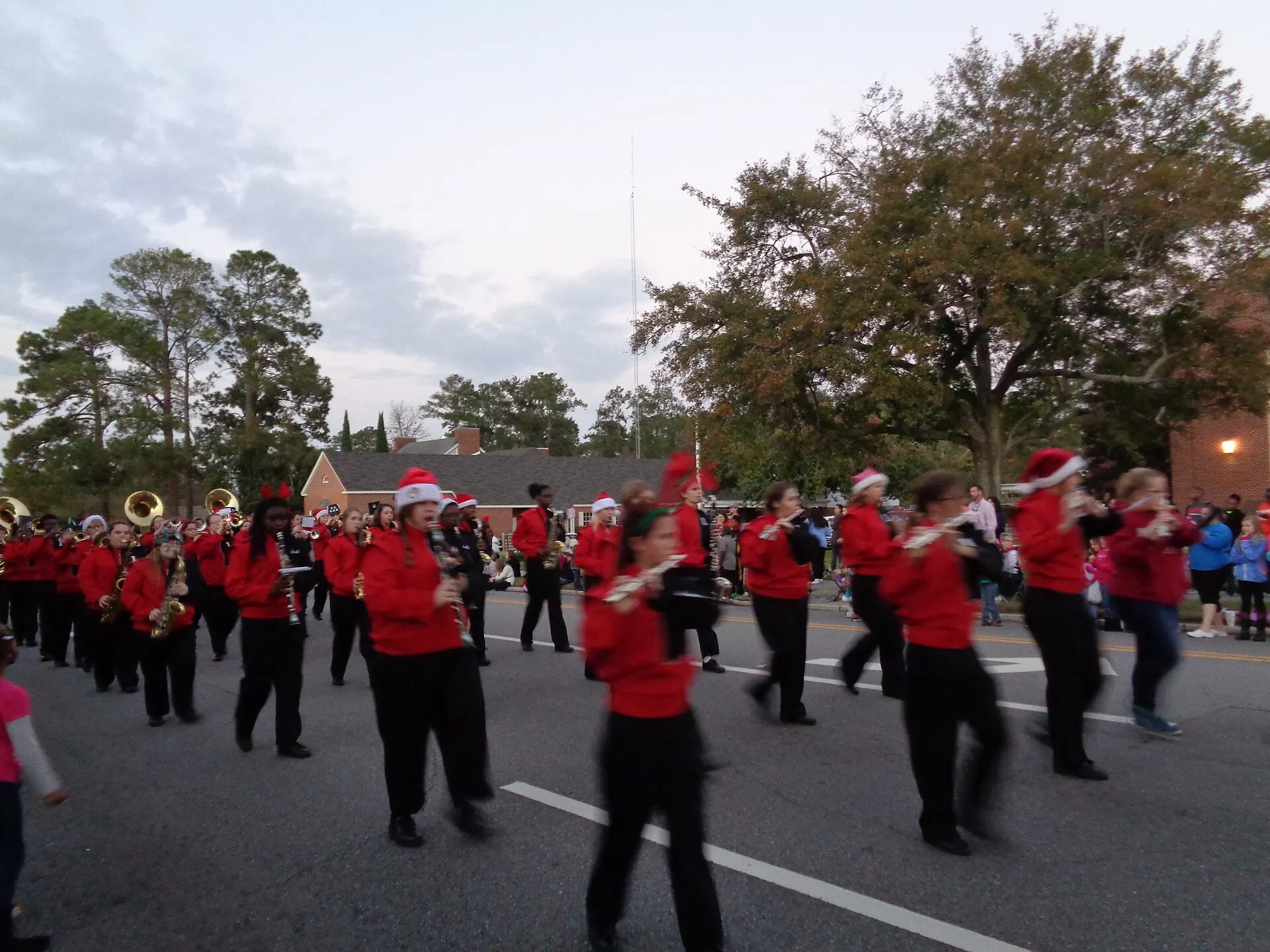 A high school marching band in Santa hats plays in a Christmas parade in Valdosta, Ga.