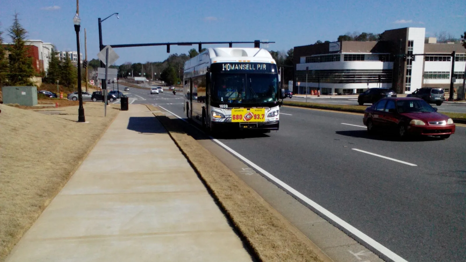 A sidewalk along Old Milton Parkway near Avalon in Alpharetta, with a MARTA bus heading for the Mansell park-and-ride